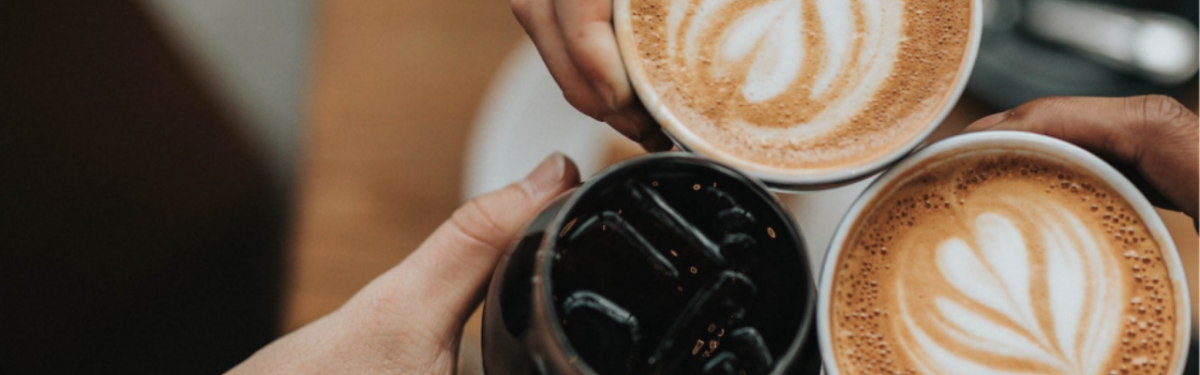 Three hands holding cups of coffee